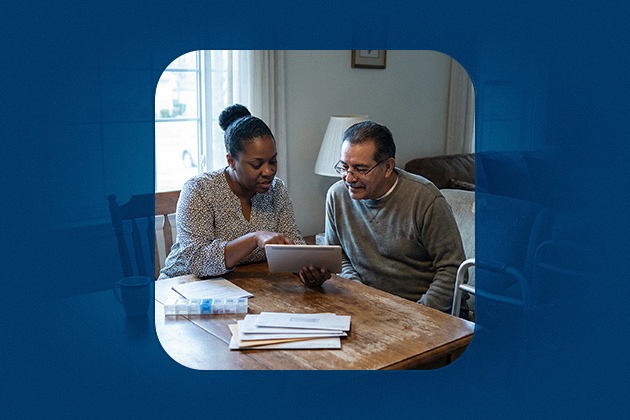 A caretaker reviews ssdi application documents on a tablet with an elderly man at home