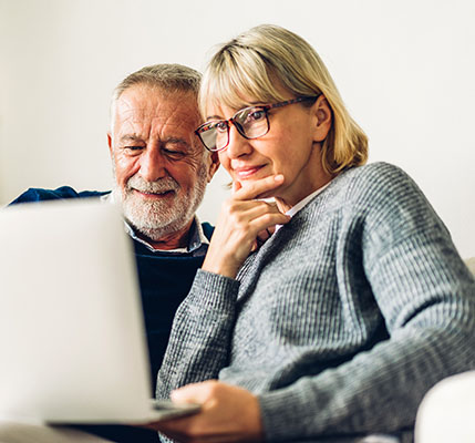 Senior couple family having good time using laptop computer together