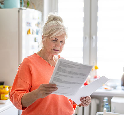 Woman looking at documents in her kitchen